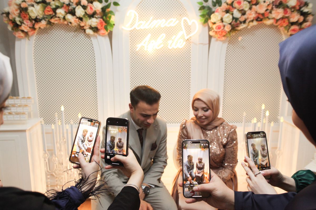 Wedding guests capturing the same celebration from several phones.