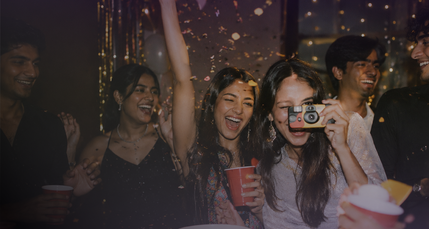 Friends celebrating at a party while taking photos.